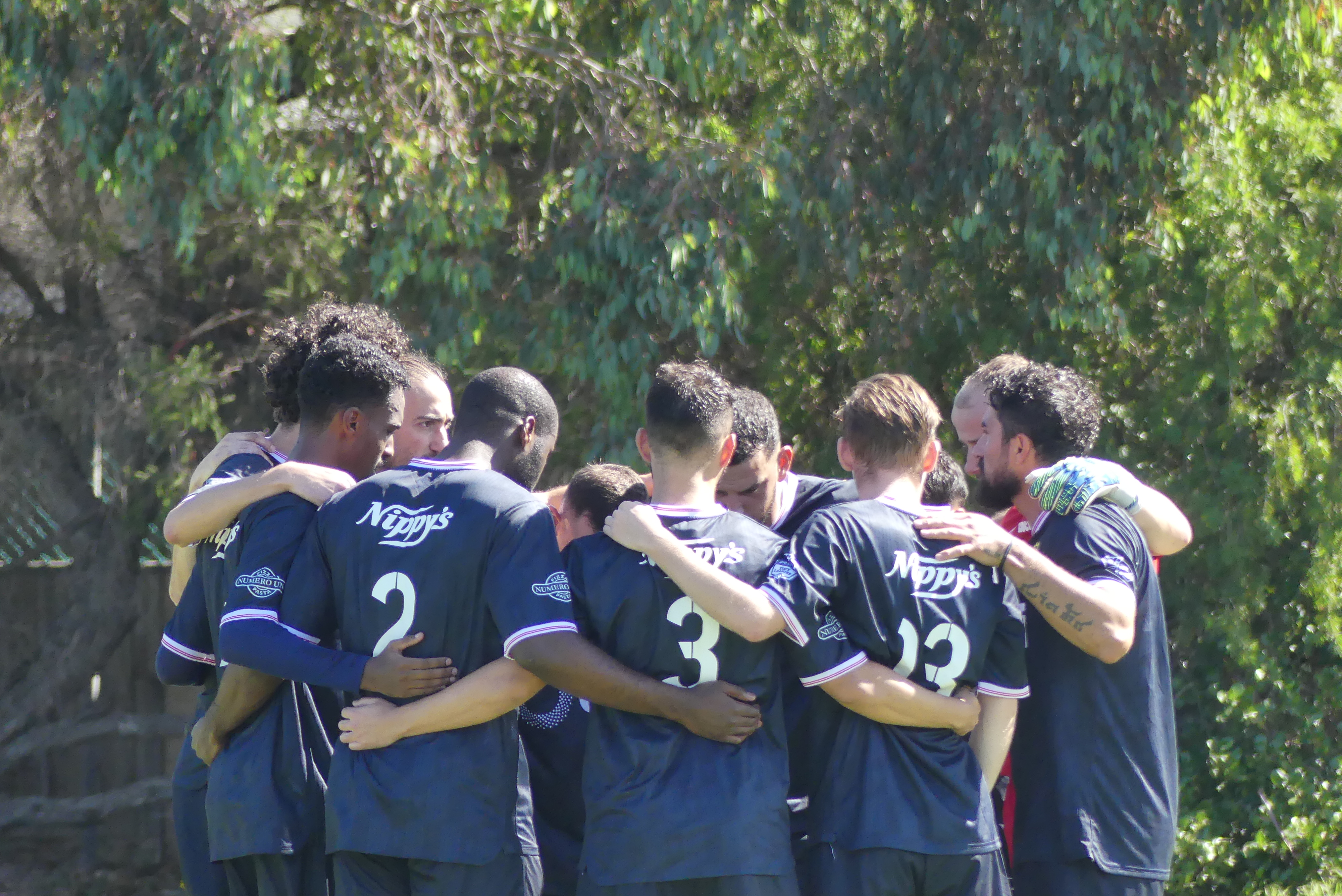 Altona North SC senior players in a team huddle